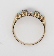 A modern 9ct gold, three stone white opal and four stone diamond set half hoop ring, size N, gross weight 2.4 grams.